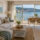 Salón decorado para una segunda vivienda en Sanxenxo con sofá, cortinas y mobiliario funcional
