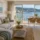 Salón decorado para una segunda vivienda en Sanxenxo con sofá, cortinas y mobiliario funcional
